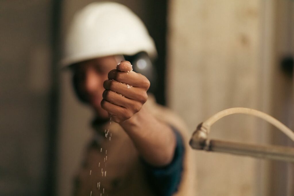 pexels-photo-29411306 A worker in a hard hat holds granules, symbolizing the urea industry in Libya.